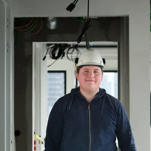 Profielfoto bij de functie monteur gas/water in de sector energie. Jonge man aan het werk in nieuwbouw.