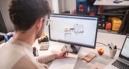 Profielfoto van functie tekenaar in de sector bouw. Man met bril werkt aan het ontwerp van een huis op computerscherm.