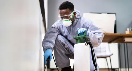 Profielfoto van de plaagdierbestrijder. De plaagdierbestrijder in beschermende kleren en een mondmasker.