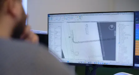 Profielfoto bij de functie tekenaar. Man achter zijn computerscherm kijkend naar een technische tekening